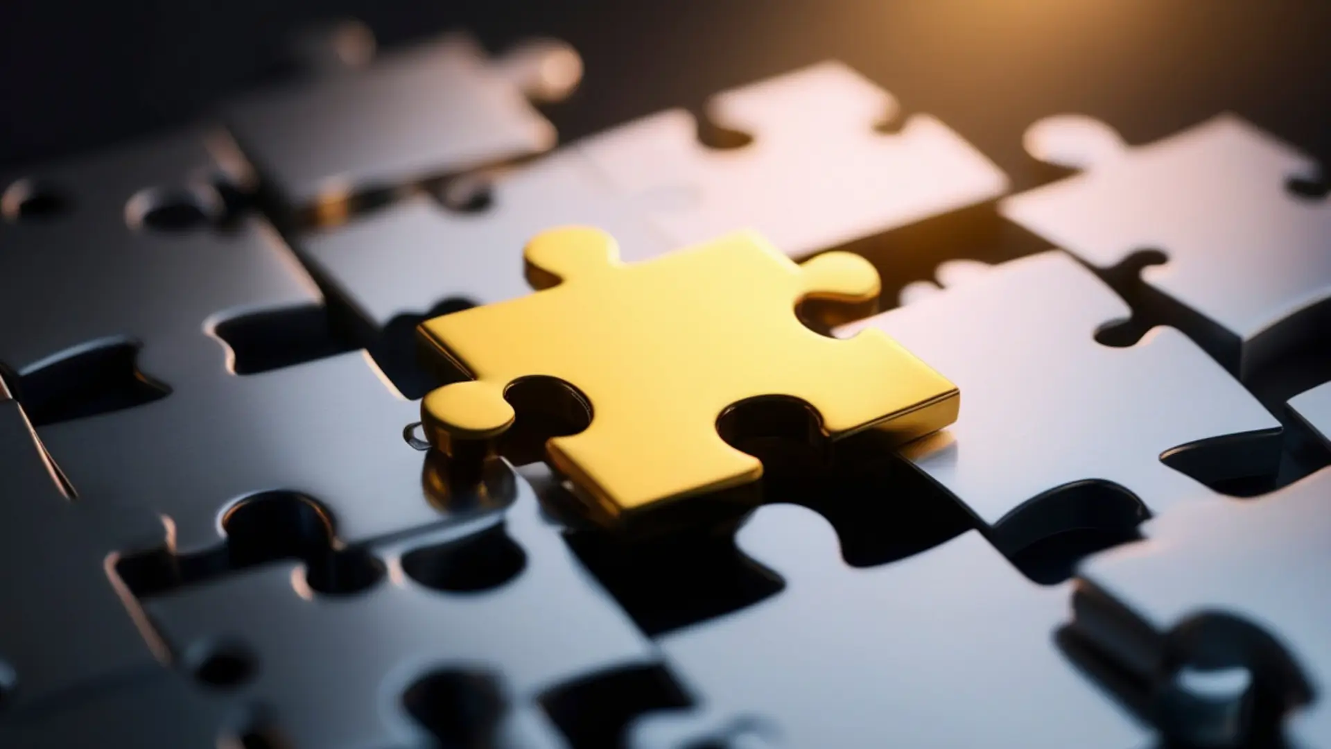 Pièce de puzzle dorée posée au-dessus de son emplacement, au milieu de pièces métalliques grises assemblées